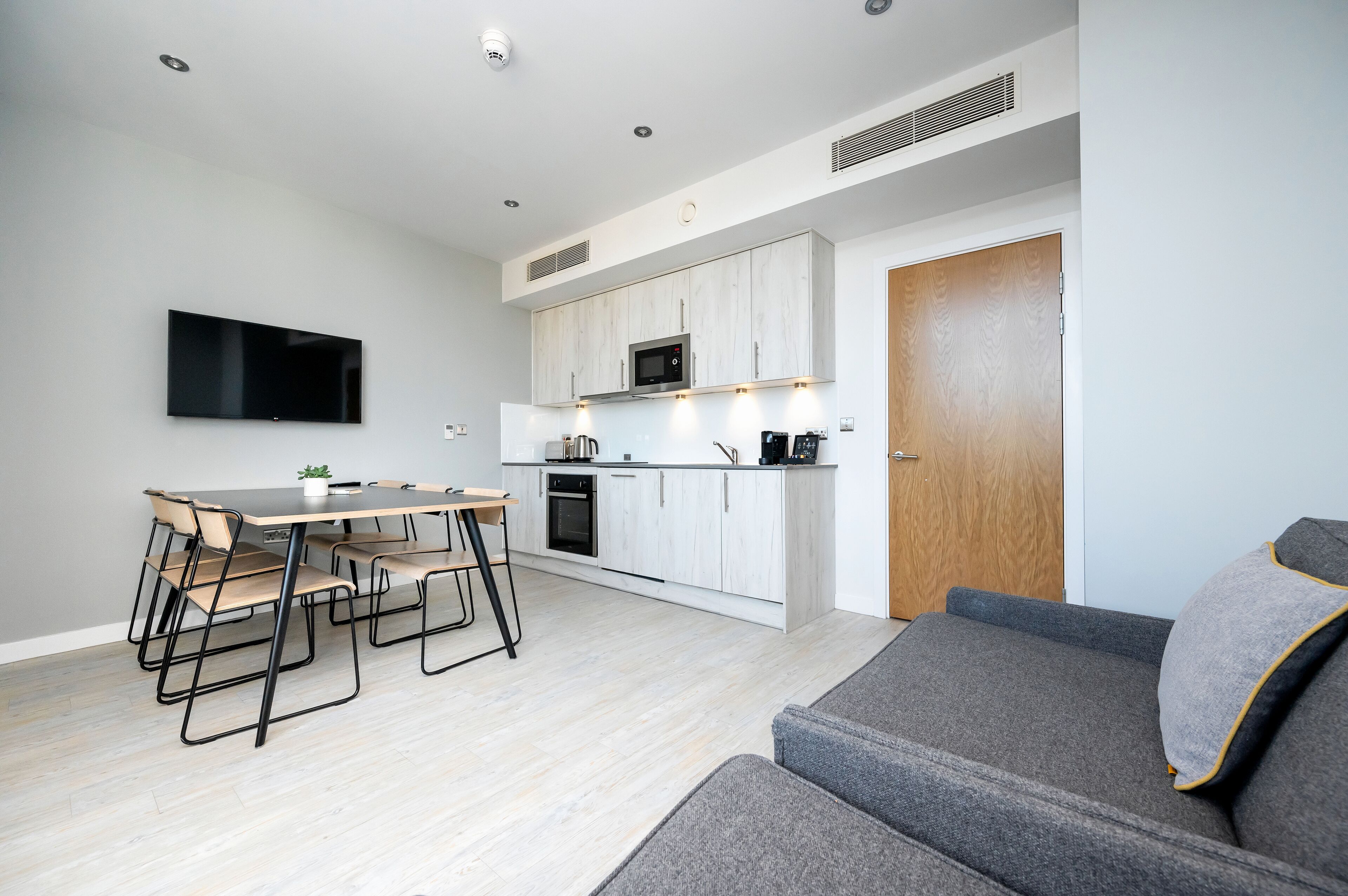 Una cocina moderna con comedor, televisor de pantalla plana y sofá.