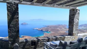 Uma construção de pedra com vista para o mar e ilhas distantes.