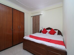 Une chambre à coucher avec un lit en bois, des oreillers rouges et une grande armoire.
