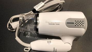 A white hair dryer with a transparent water bottle attached, labeled 'naturam' and 'TESCOM TID295'.