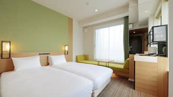 Habitación de hotel con dos camas, un escritorio, una silla, una ventana con cortinas y un televisor.