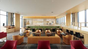 Un restaurant modern amb una zona central de seients, sostres alts i grans finestres.