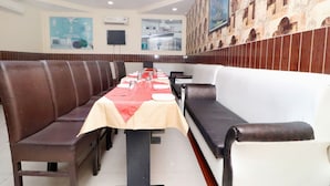 A restaurant with booths and a long table set for dining.