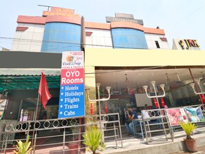Een hotel met een bordje voor OYO Rooms, dat hotels, vakanties, vluchten, treinen en taxi's aanbiedt.
