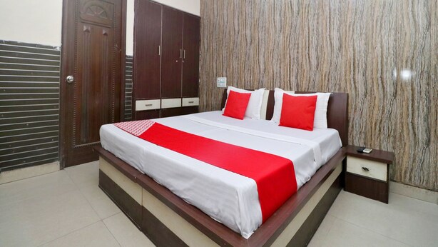 A bedroom with a bed, a nightstand, a wardrobe, and a wall-mounted air conditioner.