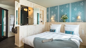 A bedroom with a large bed, wooden headboard, and a mirror cabinet. - Marias Platzl (Munich)