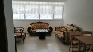 A spacious living room with a sofa set, a coffee table, and a dining table with chairs.