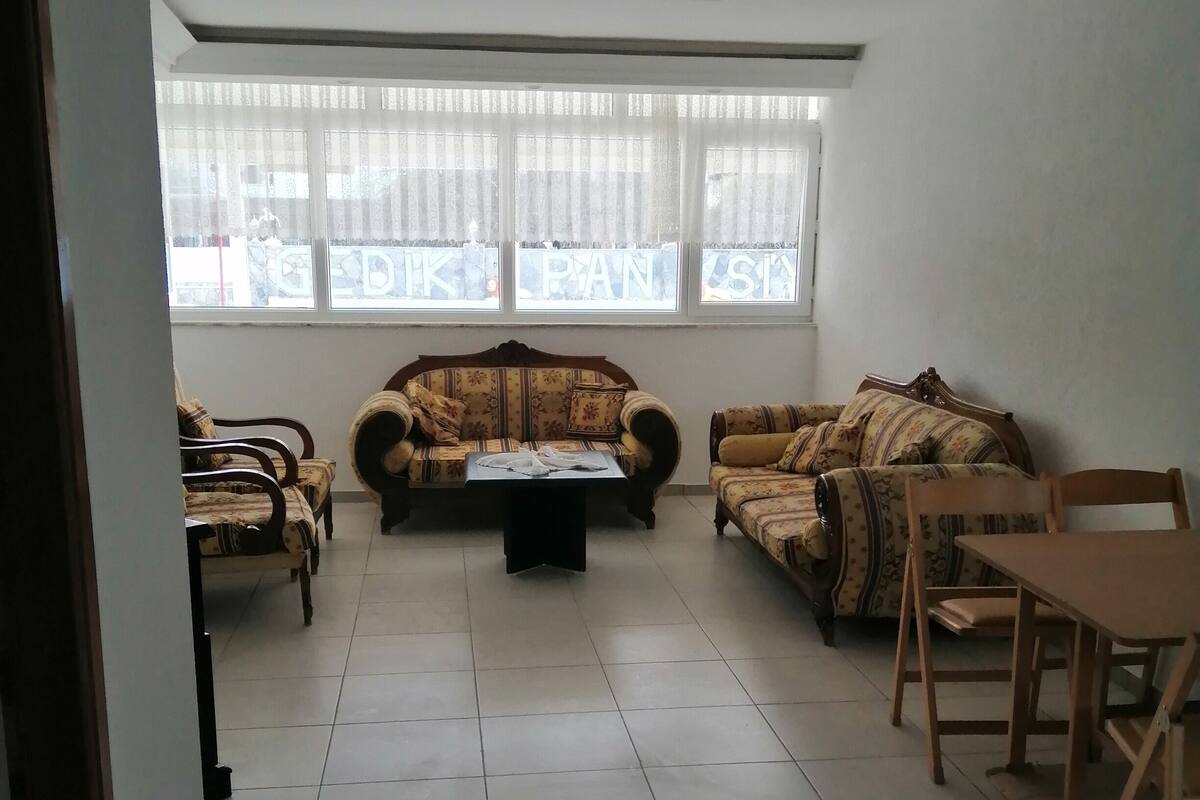 A spacious living room with a sofa set, a coffee table, and a dining table with chairs.