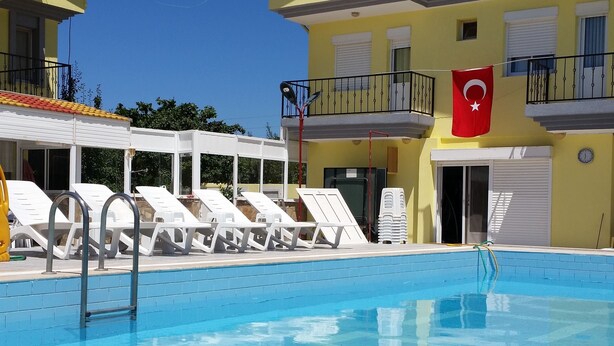 A swimming pool with lounge chairs and a flag.