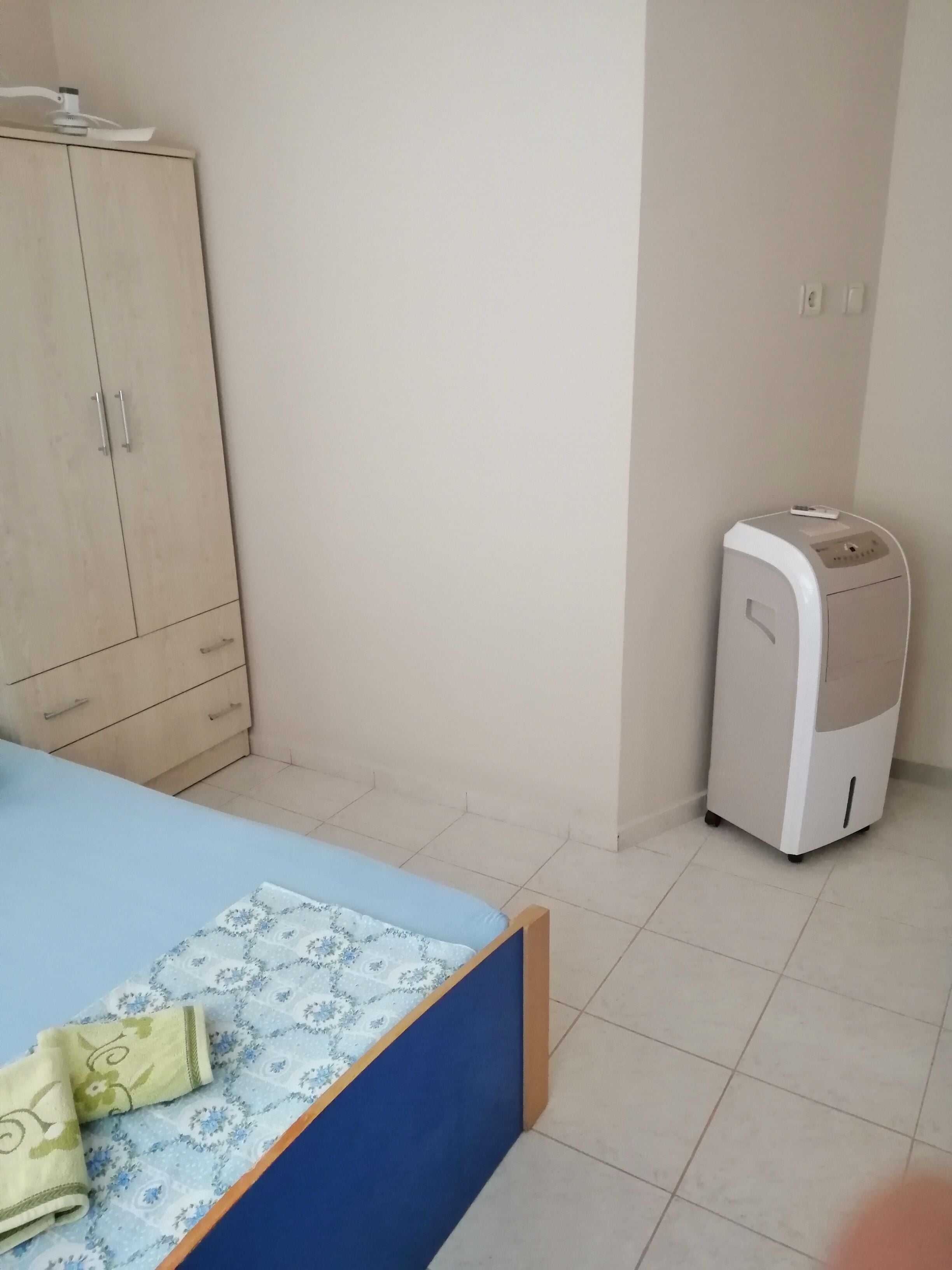 Een slaapkamer met een bed, een kledingkast en een verwarming.