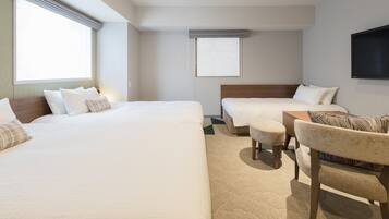 Une chambre d’hôtel avec deux lits, un canapé, une télévision et une fenêtre.