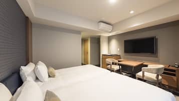 Ein modernes Hotelzimmer mit einem großen Bett, einem Schreibtisch und einem Flachbildfernseher.