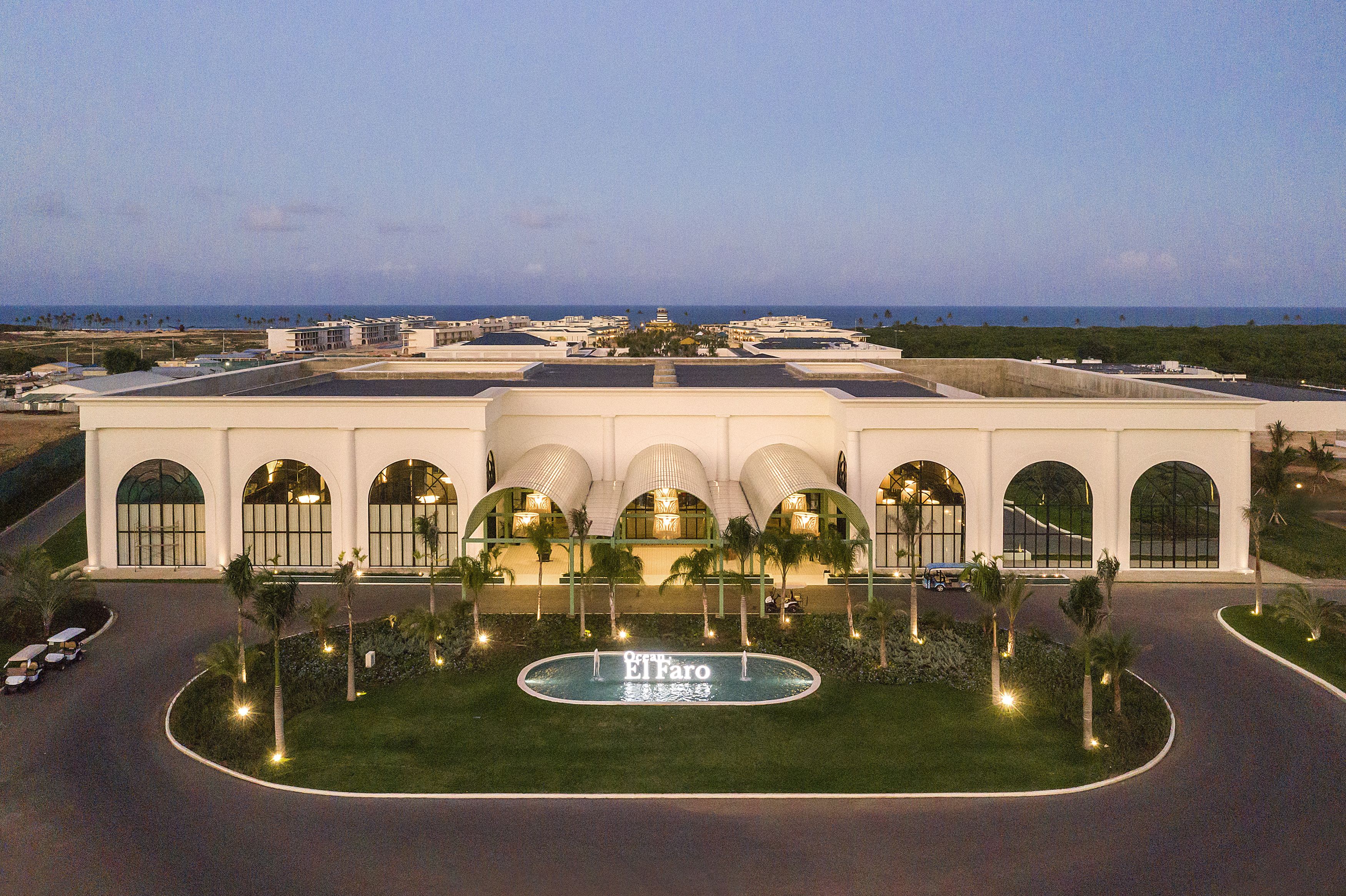 A large hotel with a central courtyard, arched windows, and a pool.