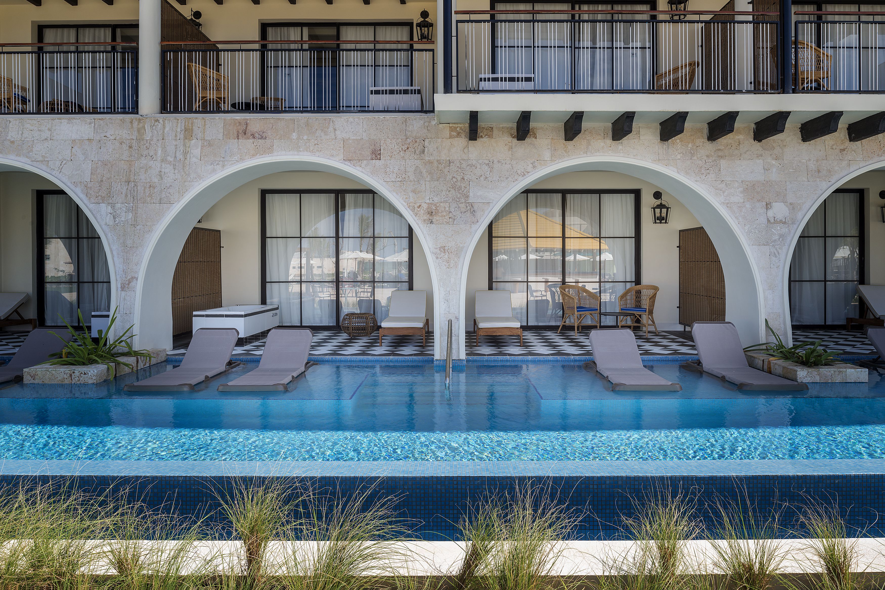 A pool area with lounge chairs and a checkered floor.