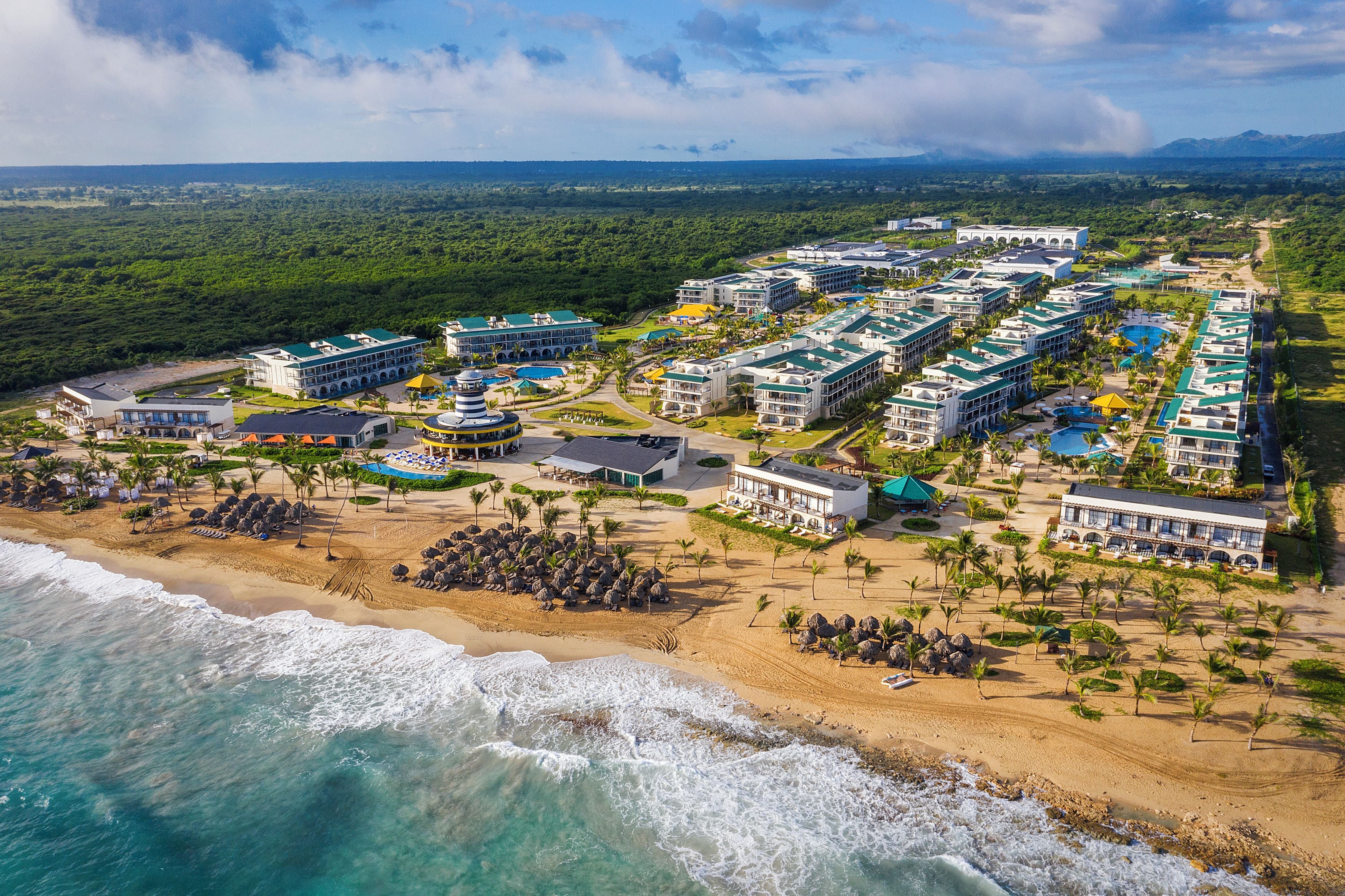 Een resort met meerdere gebouwen, een strand en een zwembad.