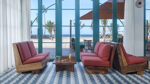 Um quarto com dois sofás acolchoados vermelhos, uma mesa de centro de madeira e um chão estampado.