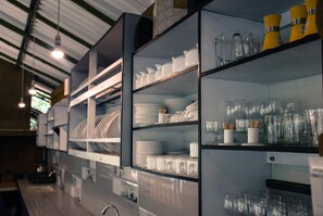 Una cocina con estantes llenos de vajilla y vasos.