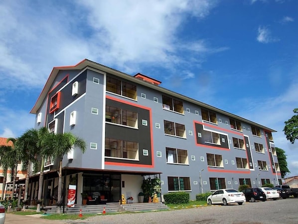 A multi-story building with a modern architectural design, featuring balconies and large windows.