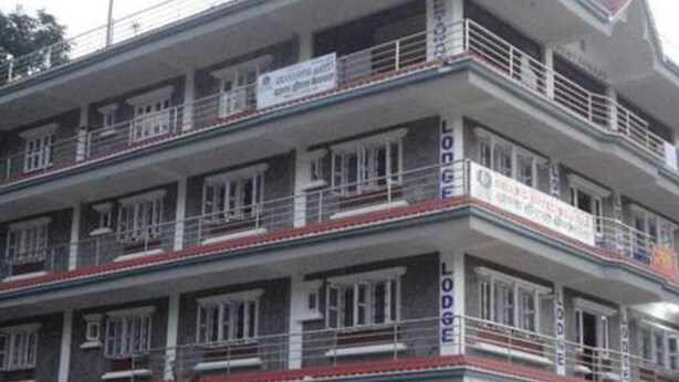 Un edificio de varios pisos con balcones y señalización que indica que es una posada.