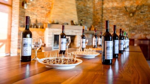 Una barra con varias botellas de vino y copas sobre una mesa de madera.