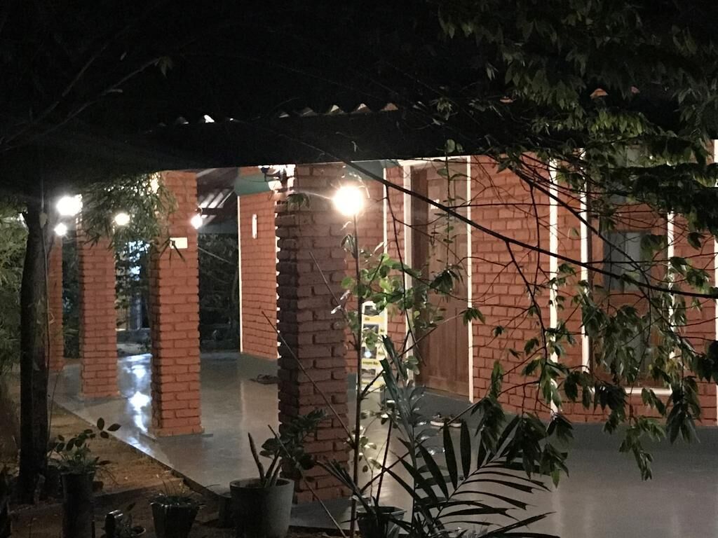 A covered outdoor area with brick pillars and potted plants.