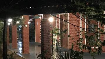 A covered outdoor area with brick pillars and potted plants.