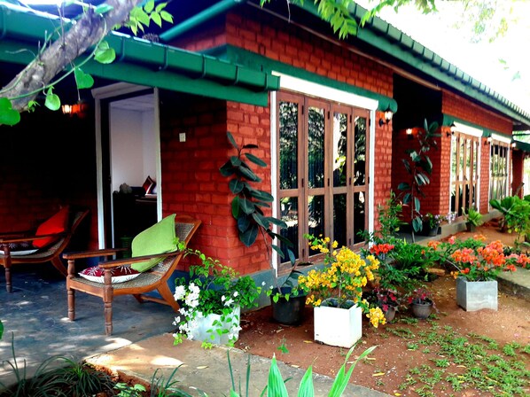 A brick house with a porch, a chair, and potted plants. - Sunshine Resort & Spa (Sigiriya)