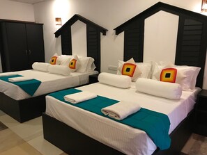 Two twin beds with white bedding and teal throw pillows, black headboards, and a dark wardrobe. - Sunshine Resort & Spa (Sigiriya)