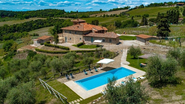 A stone villa with a swimming pool, surrounded by lush greenery and vineyards. - Agriturismo Concadoro (Castellina in Chianti)