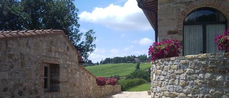 A stone building with a gravel path leading to a green landscape.