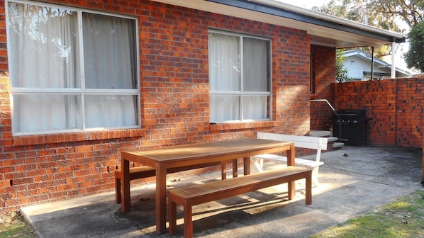 Enjoy outdoor dining and relaxation at this charming home with a picnic table and bench.