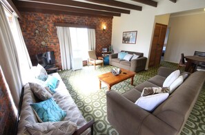 Relax in this cozy living space with a comfortable sofa set, wooden coffee table, and television.