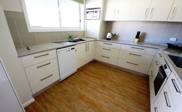 Enjoy cooking in this well-equipped kitchen with a dishwasher, sink, and microwave.