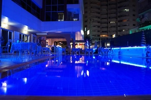 Una piscina al aire libre, sombrillas, tumbonas