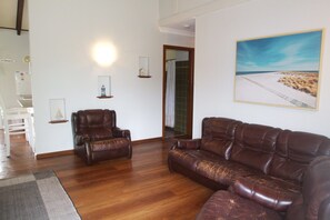 Relax in this inviting living room with a comfortable sofa, a beautiful painting, and a cozy reading nook.