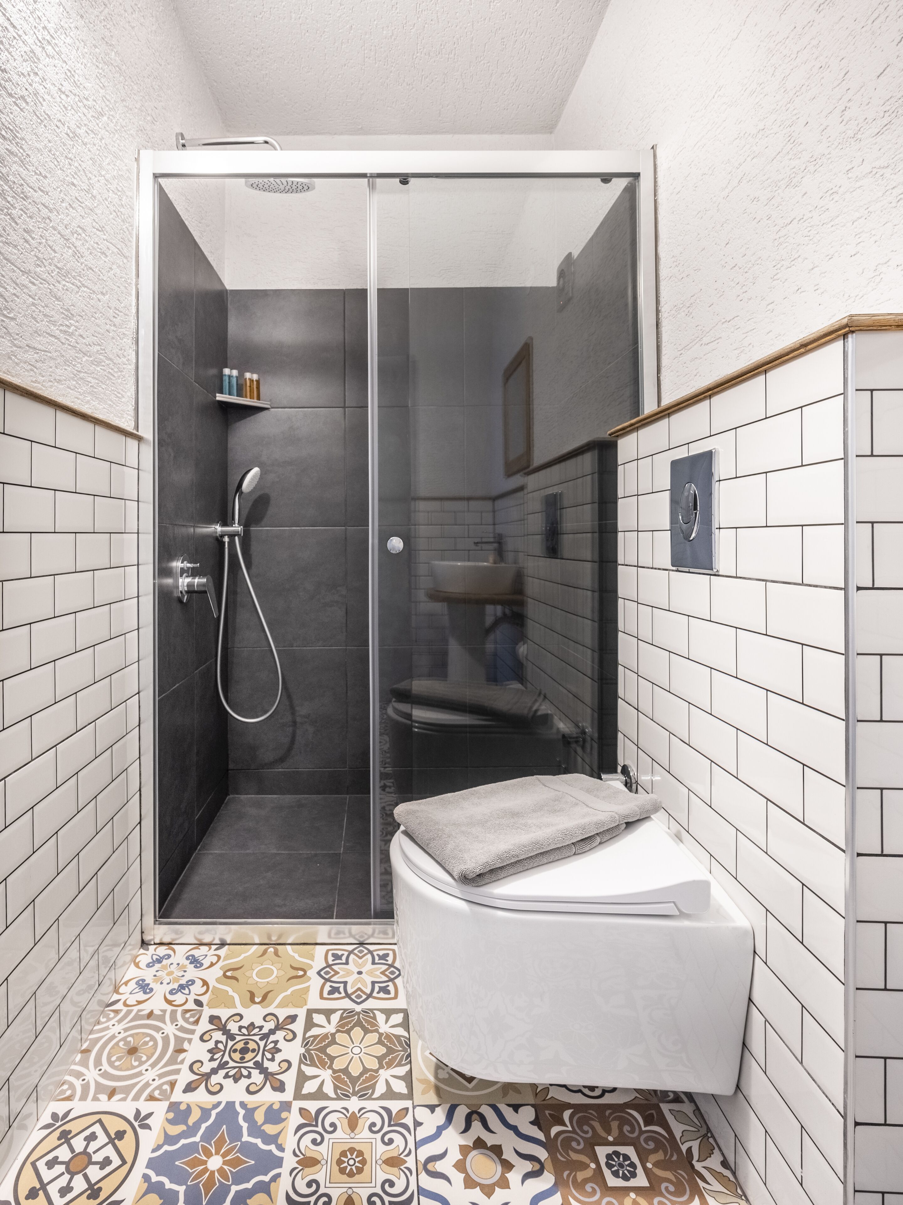 Un baño pequeño con ducha, inodoro y lavamanos.