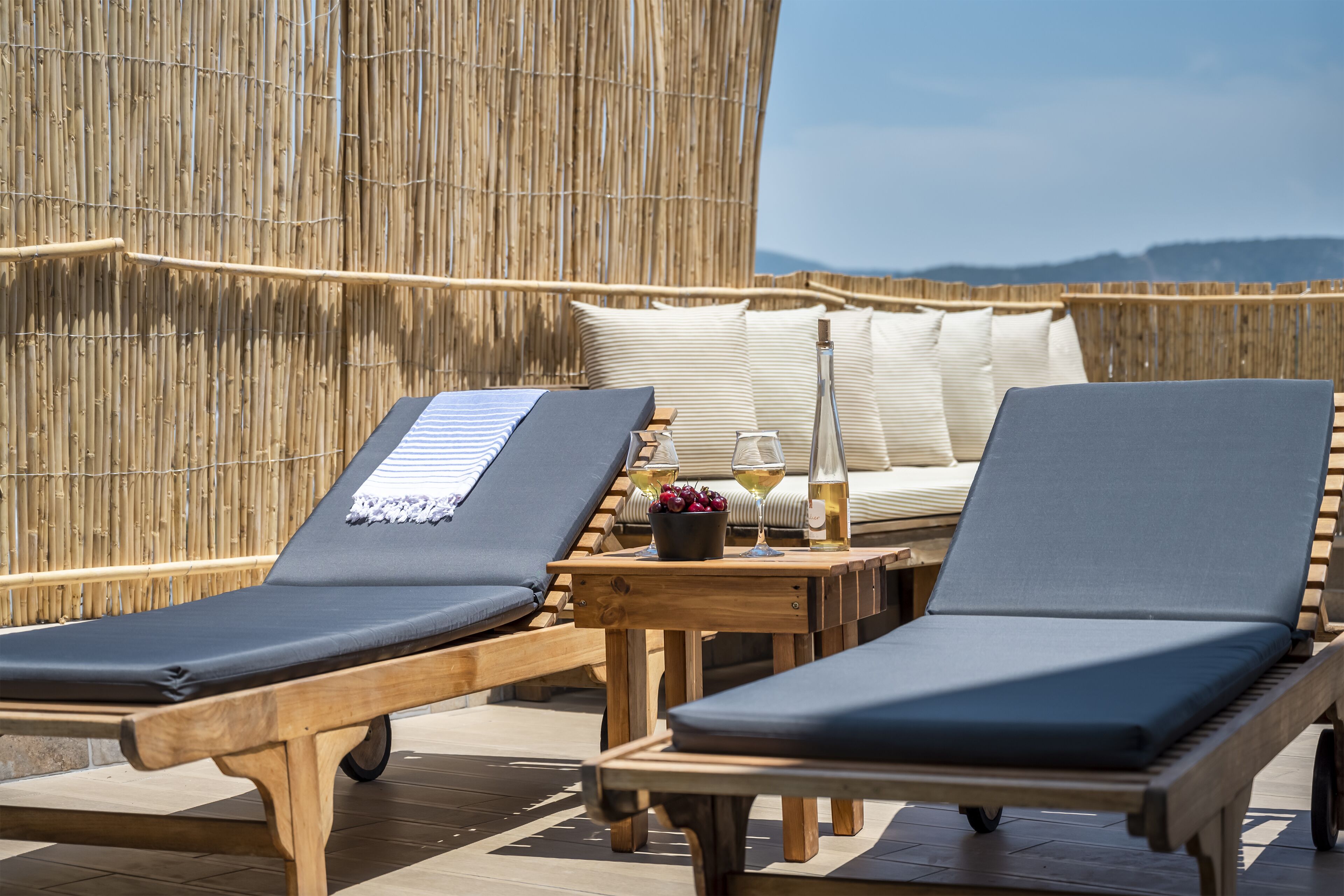 Een buitenzwembad, parasols bij het zwembad en ligstoelen