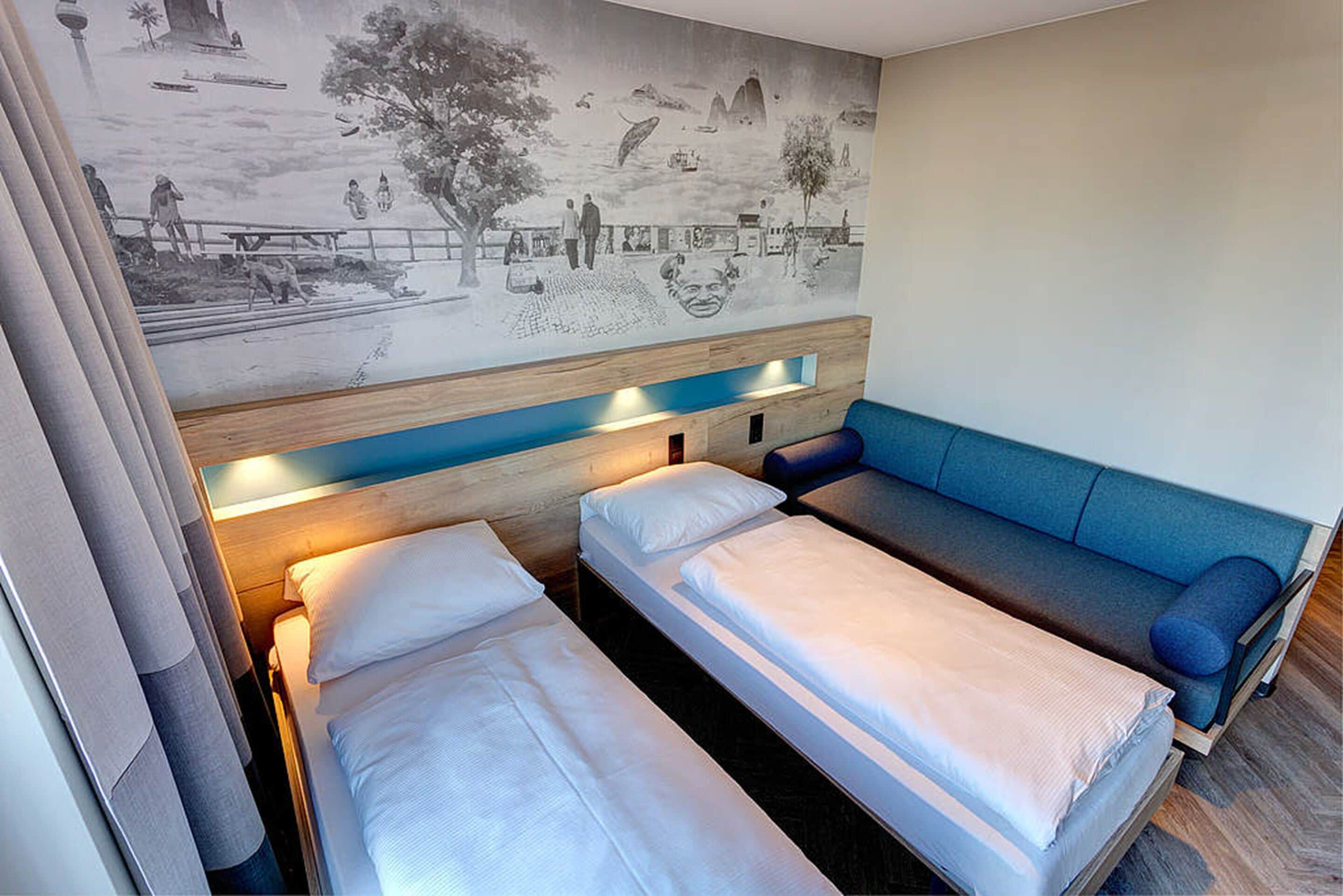 Una habitación con dos camas individuales y un sofá cama.