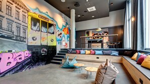 Un interior moderno con un mural, zona de estar y una escalera.