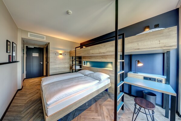 Una habitación de hotel moderna con cama, escritorio y silla.