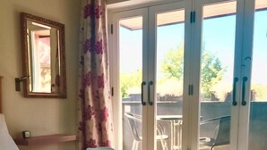 A bedroom with a bed, a window with a view of the outside, and a mirror on the wall. - Temple Lodge Club (London)