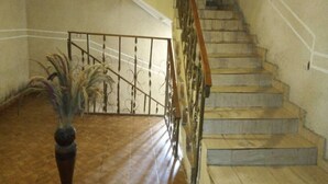 A staircase with a metal railing and a wooden handrail, leading to an upper floor. - Hotel Kama (Abidjan)