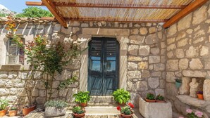 Un bâtiment en pierre avec une porte en bois et des marches menant à un porche.