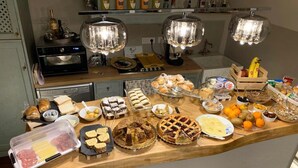 A kitchen counter with various food items, a microwave, a toaster, and a wine bottle shelf. - Leone Camere D'Autore (Naples)