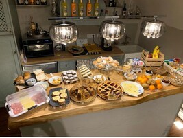 Un piano di lavoro in cucina con diversi cibi, un forno a microonde, un tostapane e una dispensa per bottiglie di vino.
