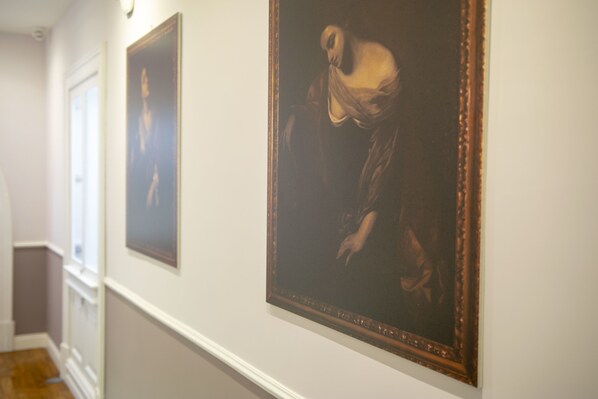 A hallway with framed artworks on the walls. - Leone Camere D'Autore (Naples)