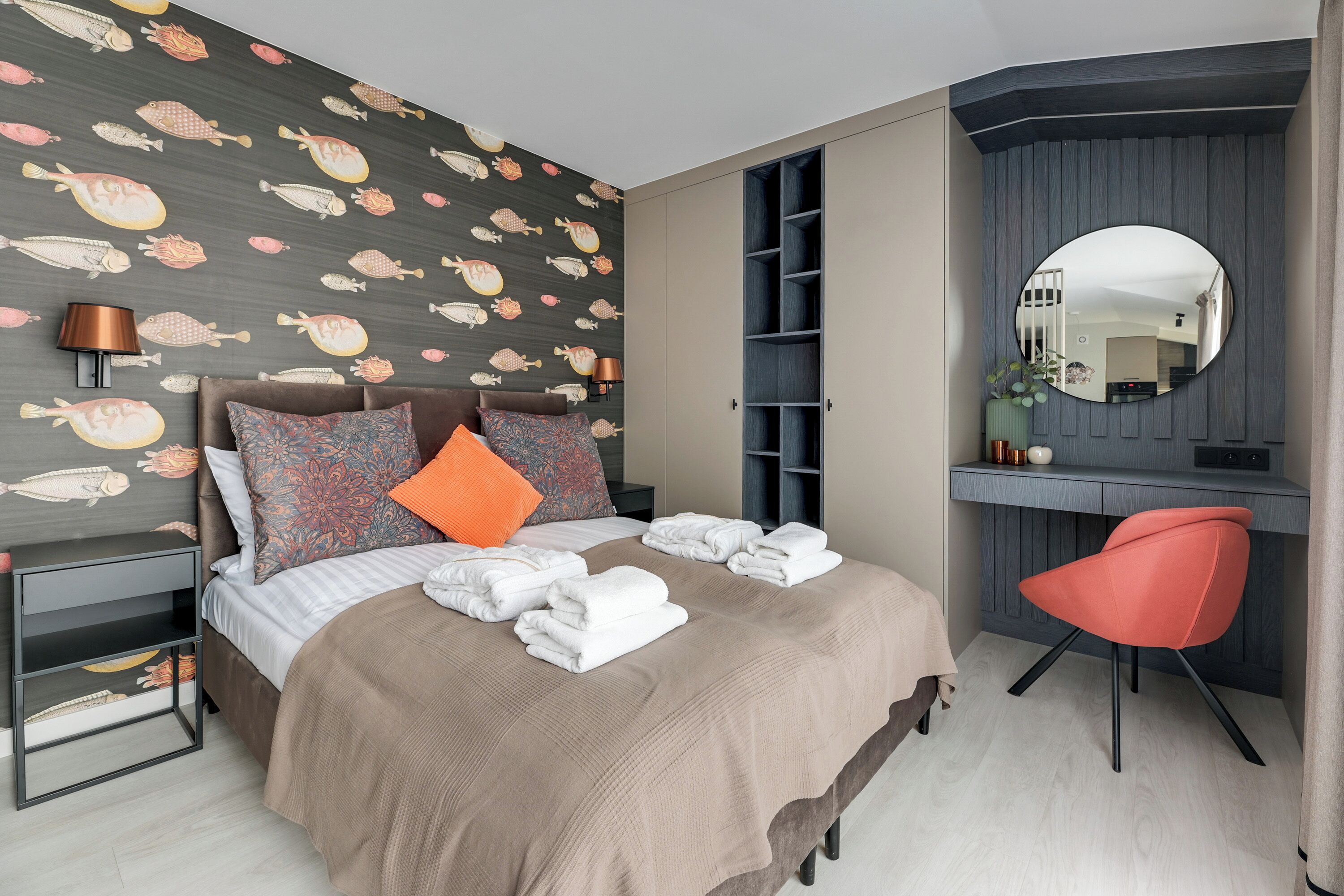 Une chambre bien rangée, avec un lit, une table de chevet, un bureau avec une chaise, un miroir et une armoire.