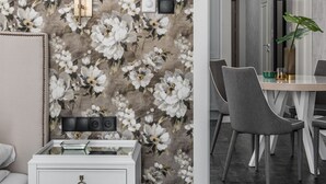 A modern living room with a floral wallpaper, a white side table with a lamp, and a dining area with a table and chairs. - Monte Carlo Luxury Suites with Parking by Lion Apartments Sopot (Sopot)