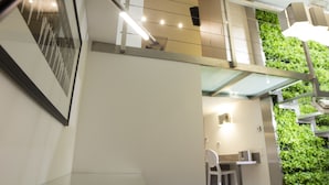 Een modern interieur met een trap, een ingelijst schilderij aan de muur en een groene wanddecoratie.