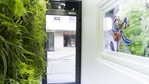 Een doorgang die uitkomt op een straat, met een winkel genaamd 'Gocoo' zichtbaar door het glas.